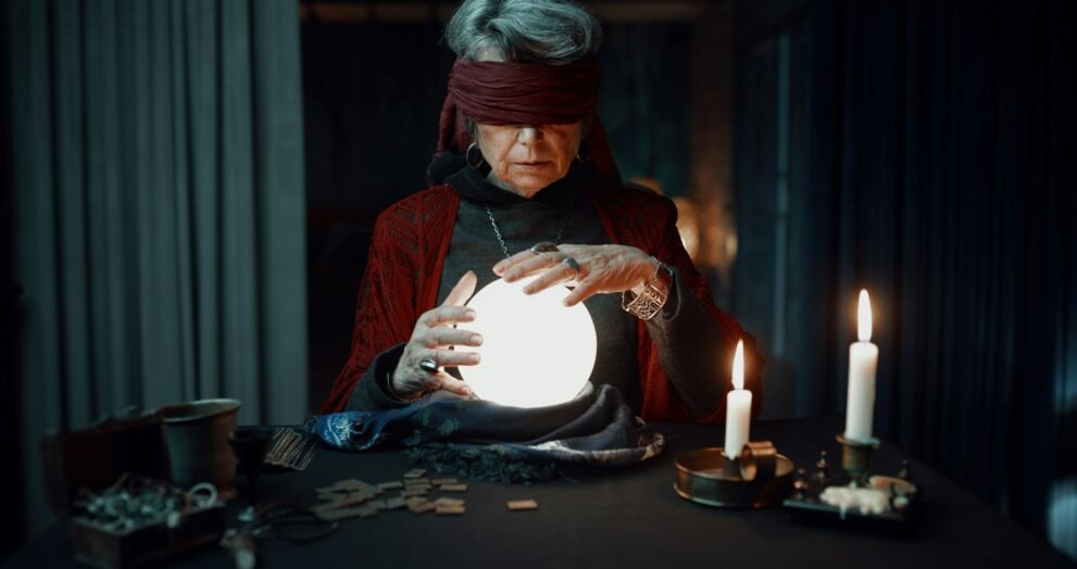 Blindfolded fortune teller using glowing crystal ball for future reading